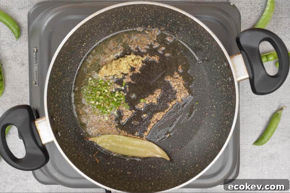 Ginger and green chilies added to the pan.