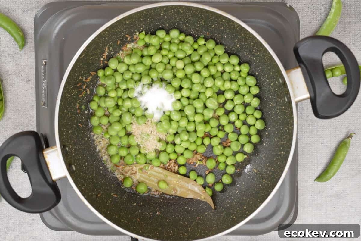 Peas, salt and sugar added to the pan.