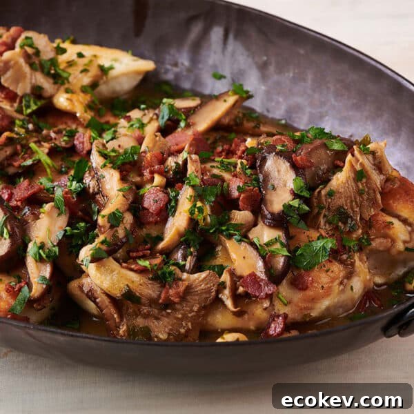 Black serving platter of Chicken Marsala.