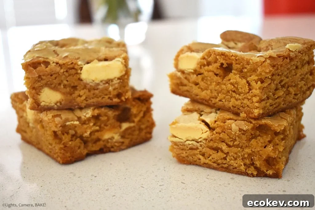 Four slices of Caramilk brownies on a white background.