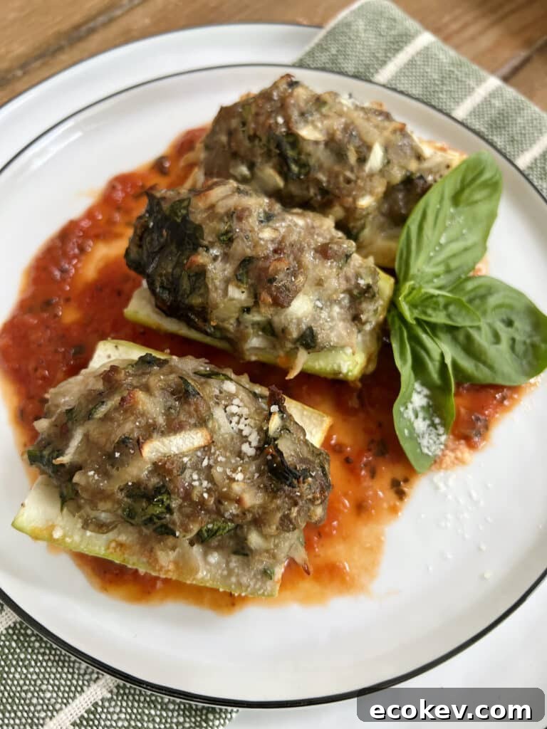Three pieces of Baked Stuffed Cucuzza Squash over tomato sauce on white plate with basil sprig garnish.