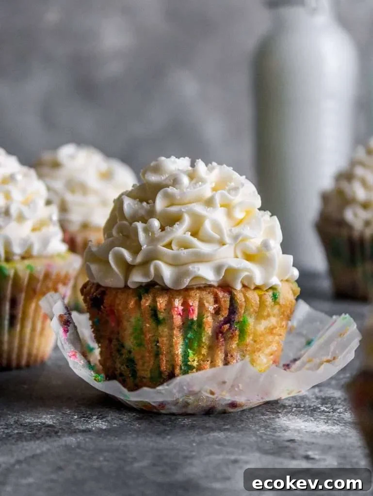 frosted funfetti cupcakes on table with cupcake unwraped (1)