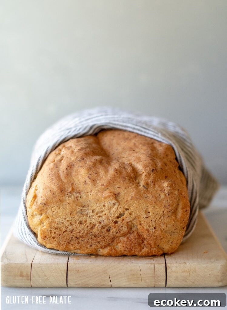 A whole loaf of homemade gluten-free sandwich bread on a cutting board.