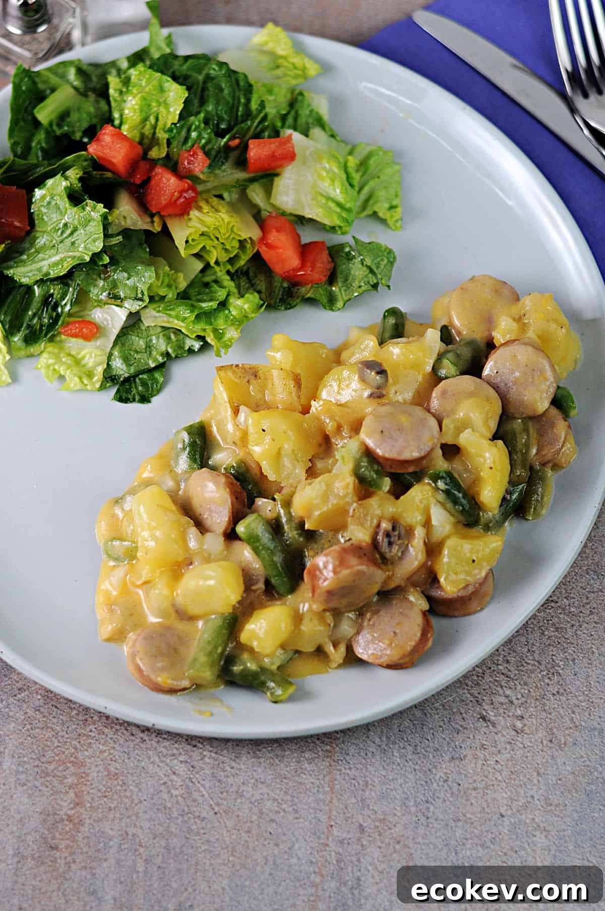 serving of brat stew or casserole on a plate with some salad.