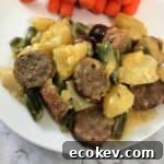 Cheesy Brat Stew on a plate with carrots