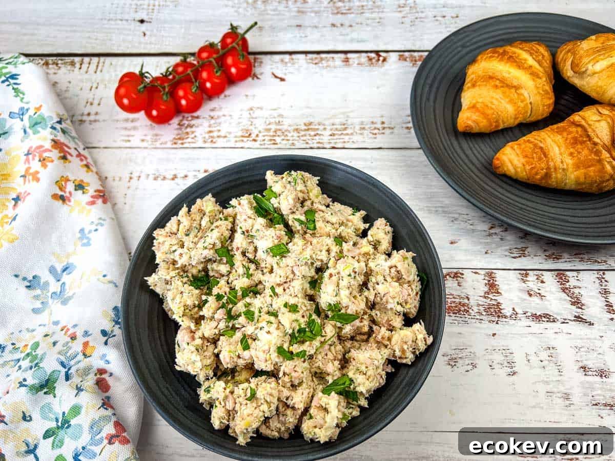 A bowl of Southern ham salad and a plate of croissants on a wooden table.