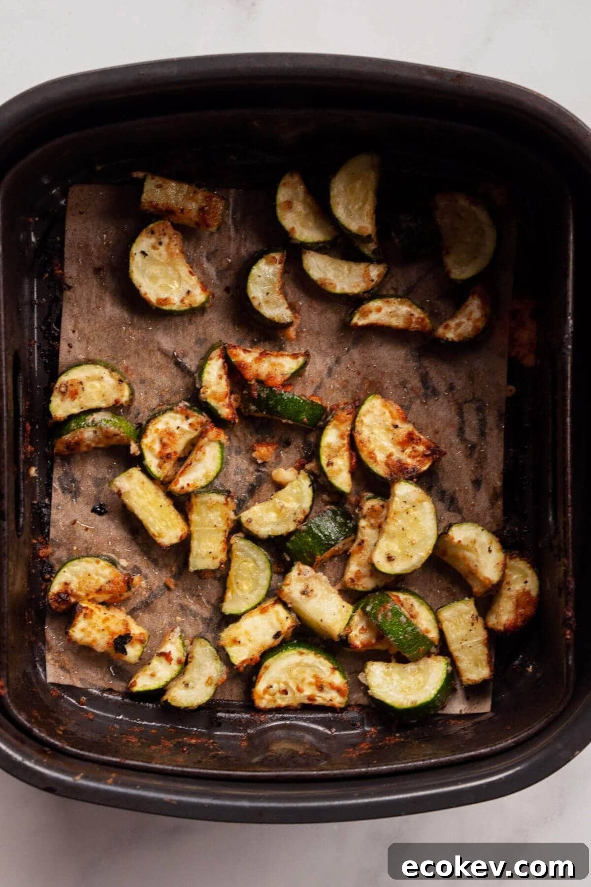 Crispy, cheesy air-fried zucchini bites with golden Parmesan edges after cooking.
