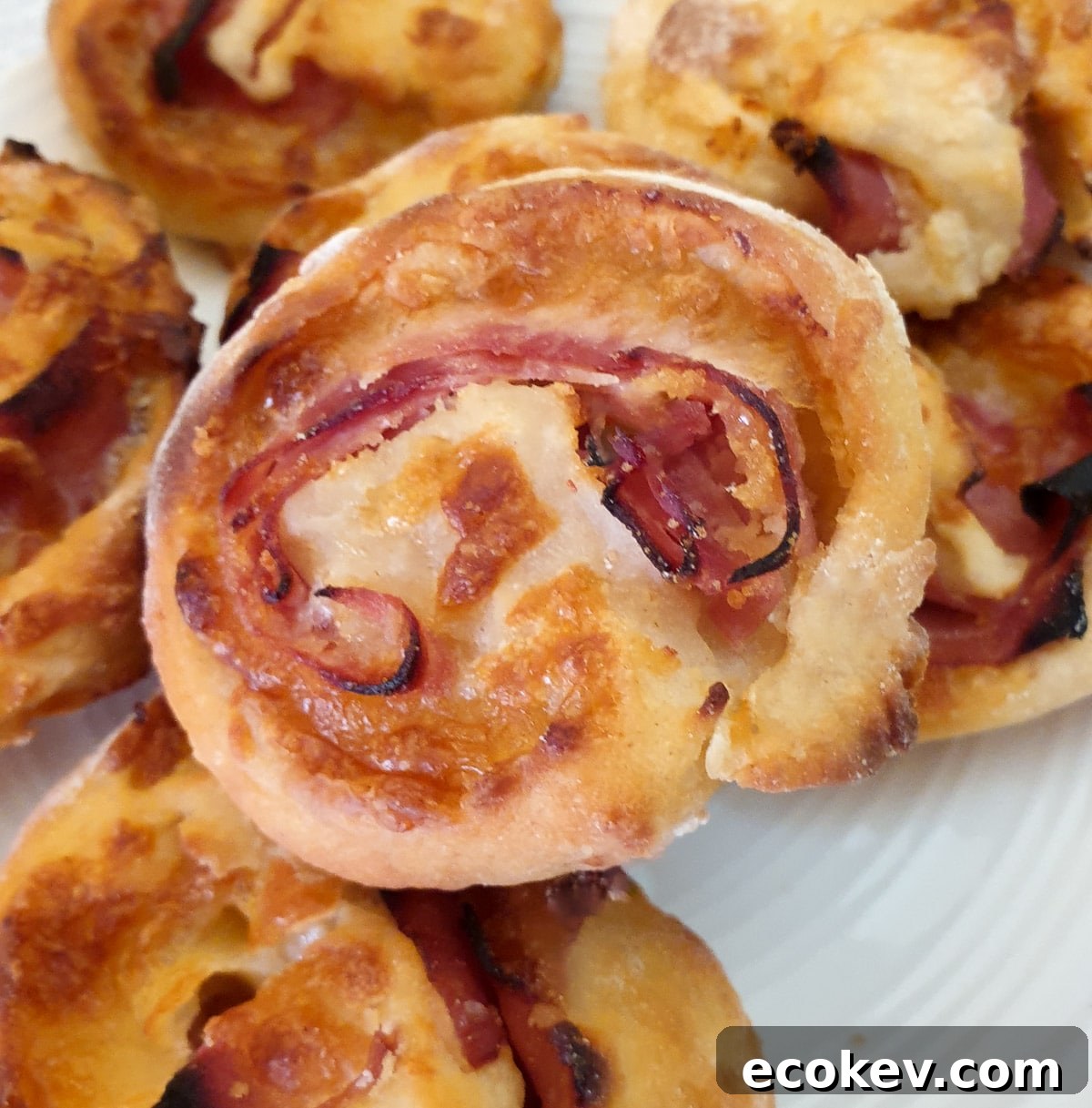 A pile of ham and cheese pinwheels on a plate.