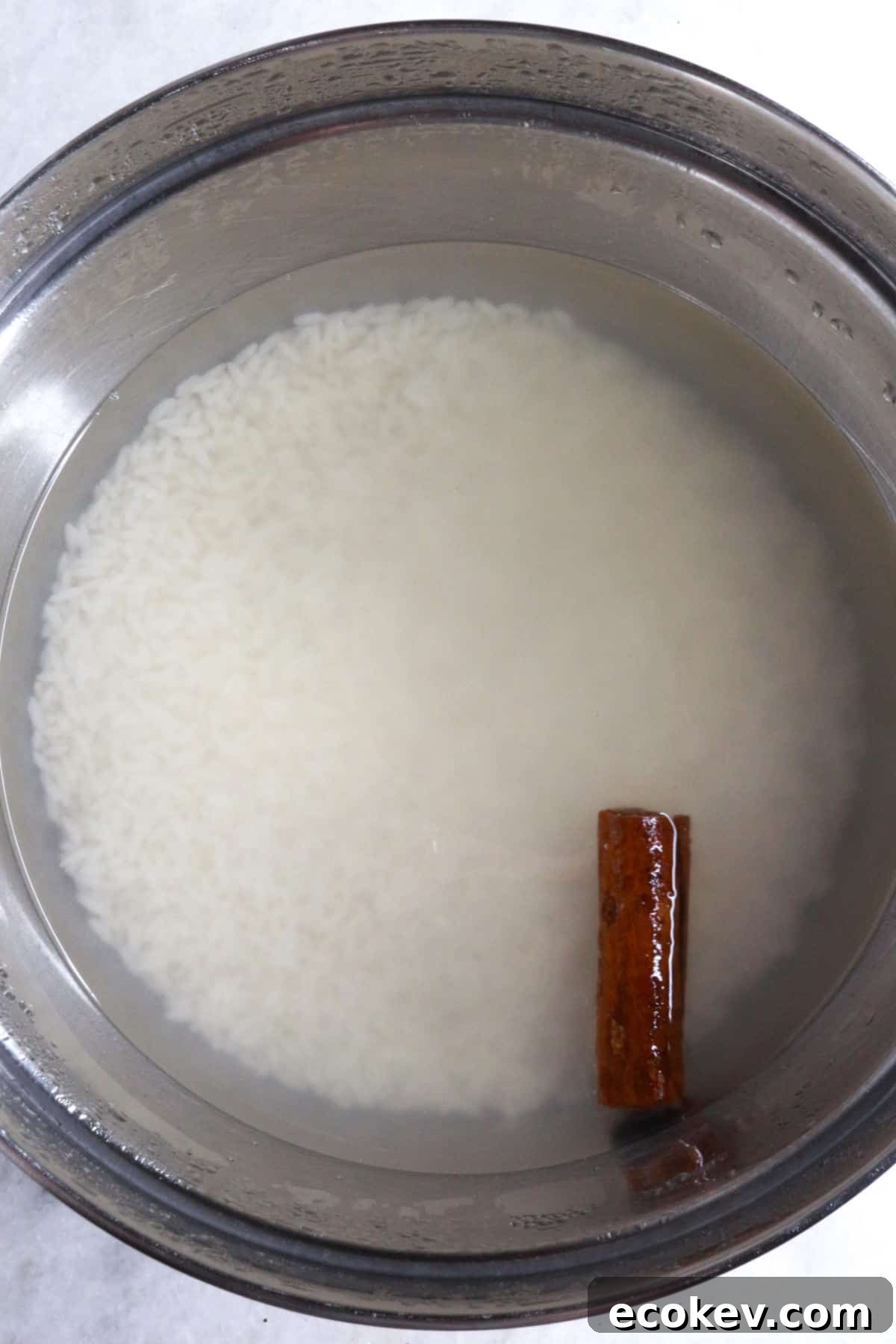 Bowl with white rice and cinnamon stick covered with water