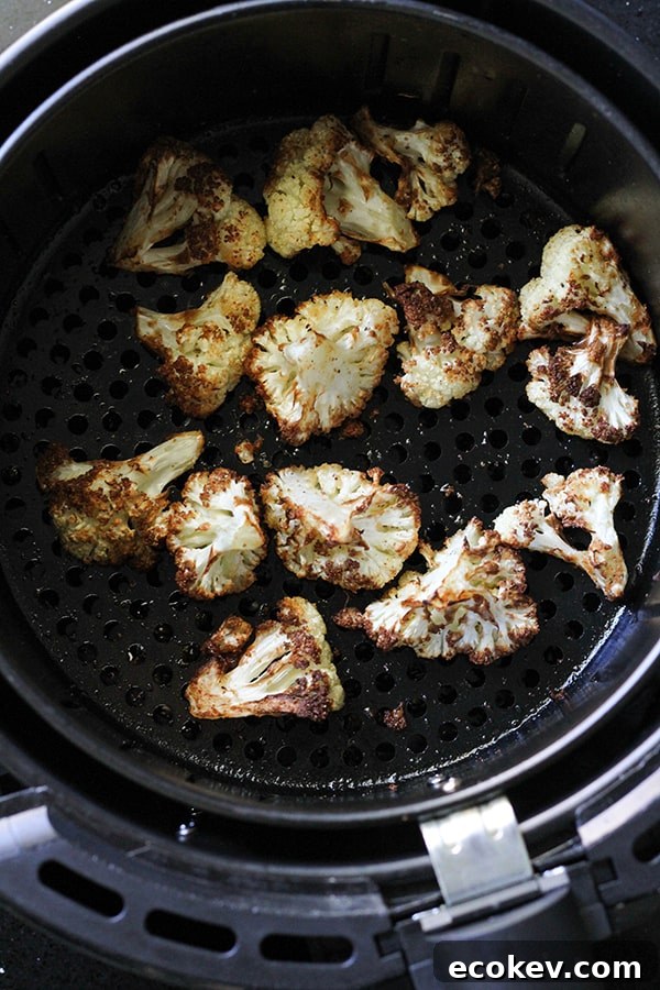 roasted cauliflower in an air fryer basket.
