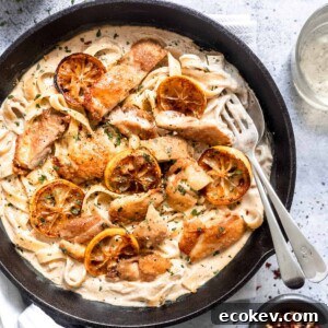 Creamy lemon chicken pasta in a skillet with parsley.