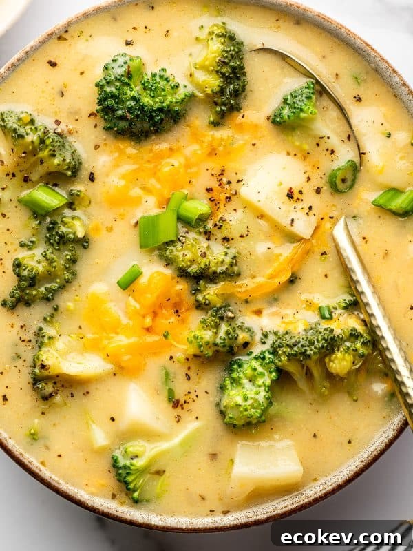Extreme close-up of creamy broccoli potato soup in a gray bowl with a brown rim.