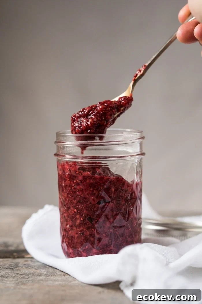 Taking a spoonful of keto raspberry chia jam