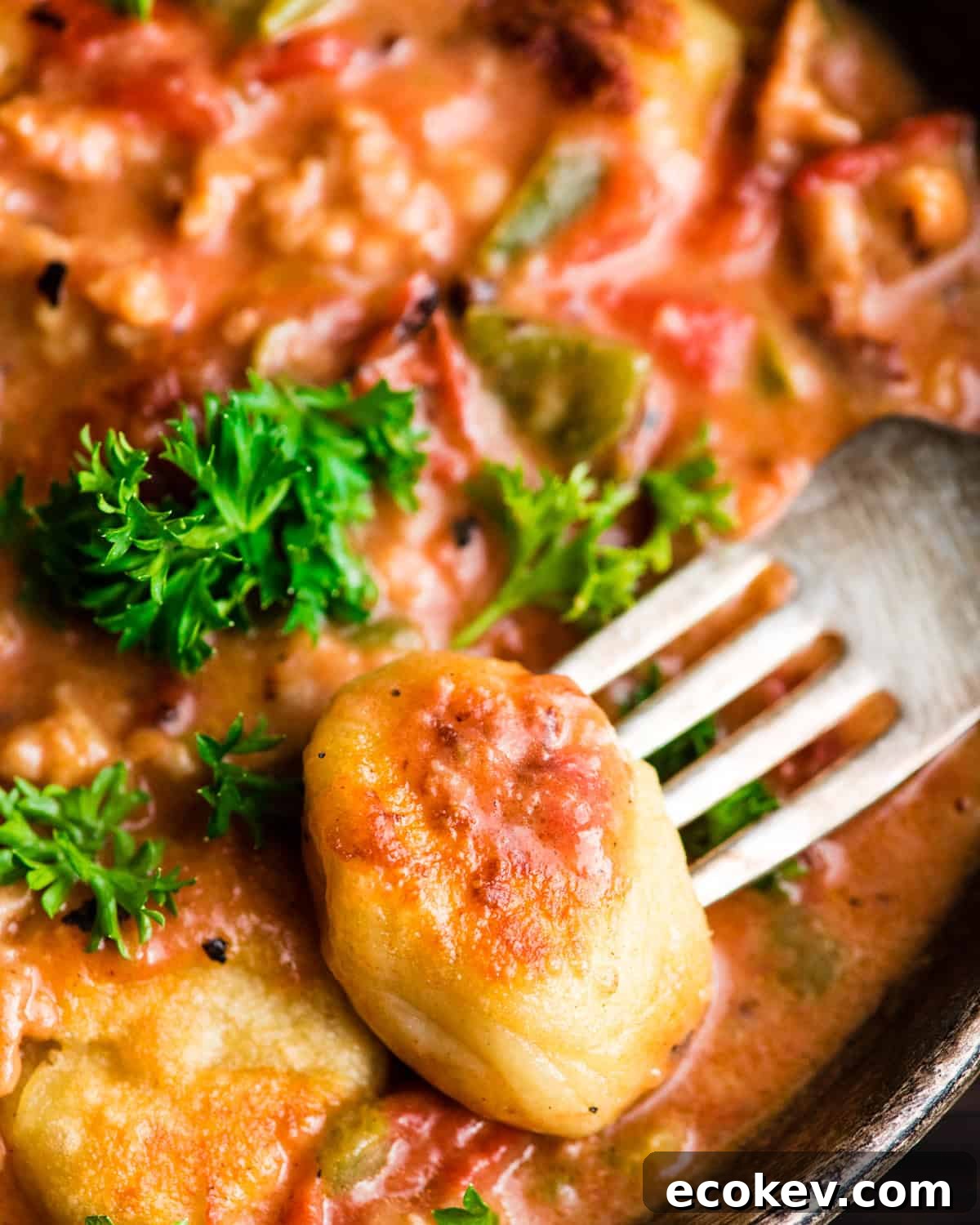 up close photo of a fork taking a bite of Sausage Gnocchi