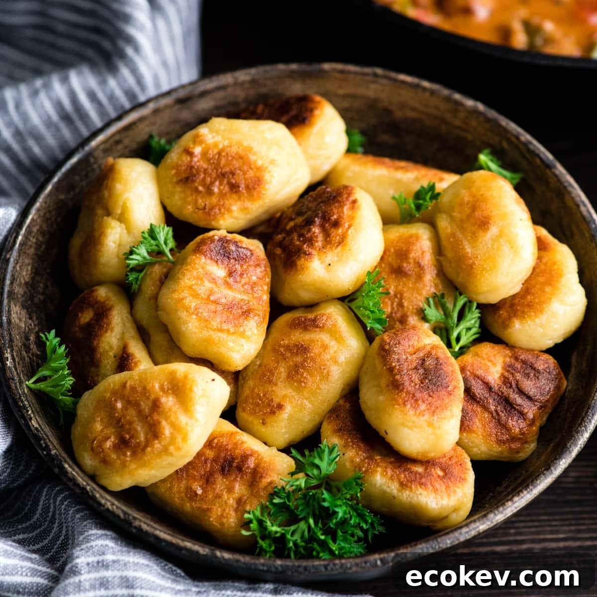 front view of a bowl full of homemade potato gnocchi that has been cooked and browned, ready to be used to make Cheesy Sausage Gnocchi recipe 