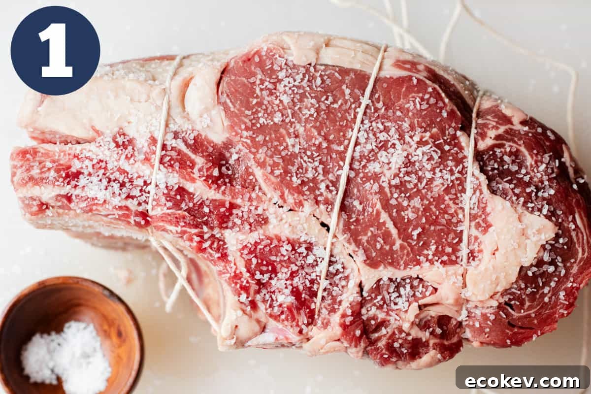 Salted prime rib roast tied together with twine.