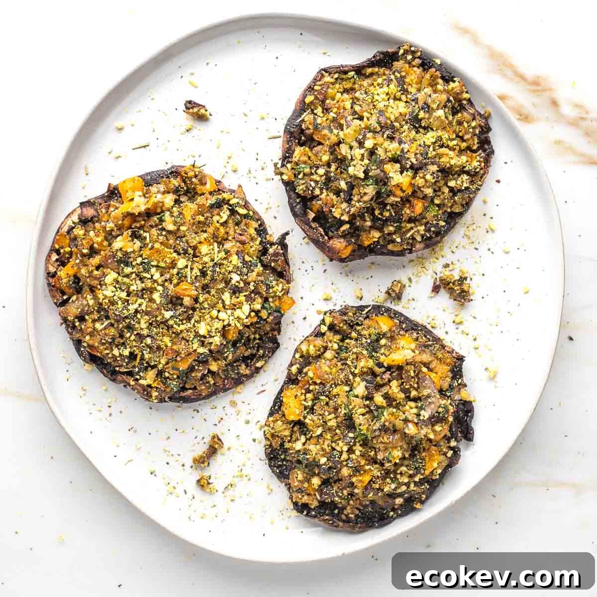 Large veggie stuffed portobello mushrooms on a plate.