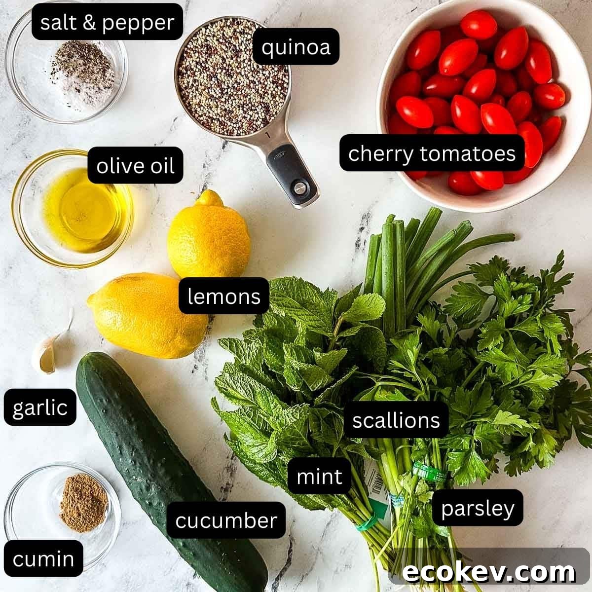 Labeled ingredients for quinoa salad on a white marble counter.