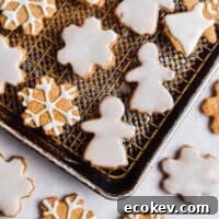 Snowflakes and gingerbread women are decorated on baking sheets.