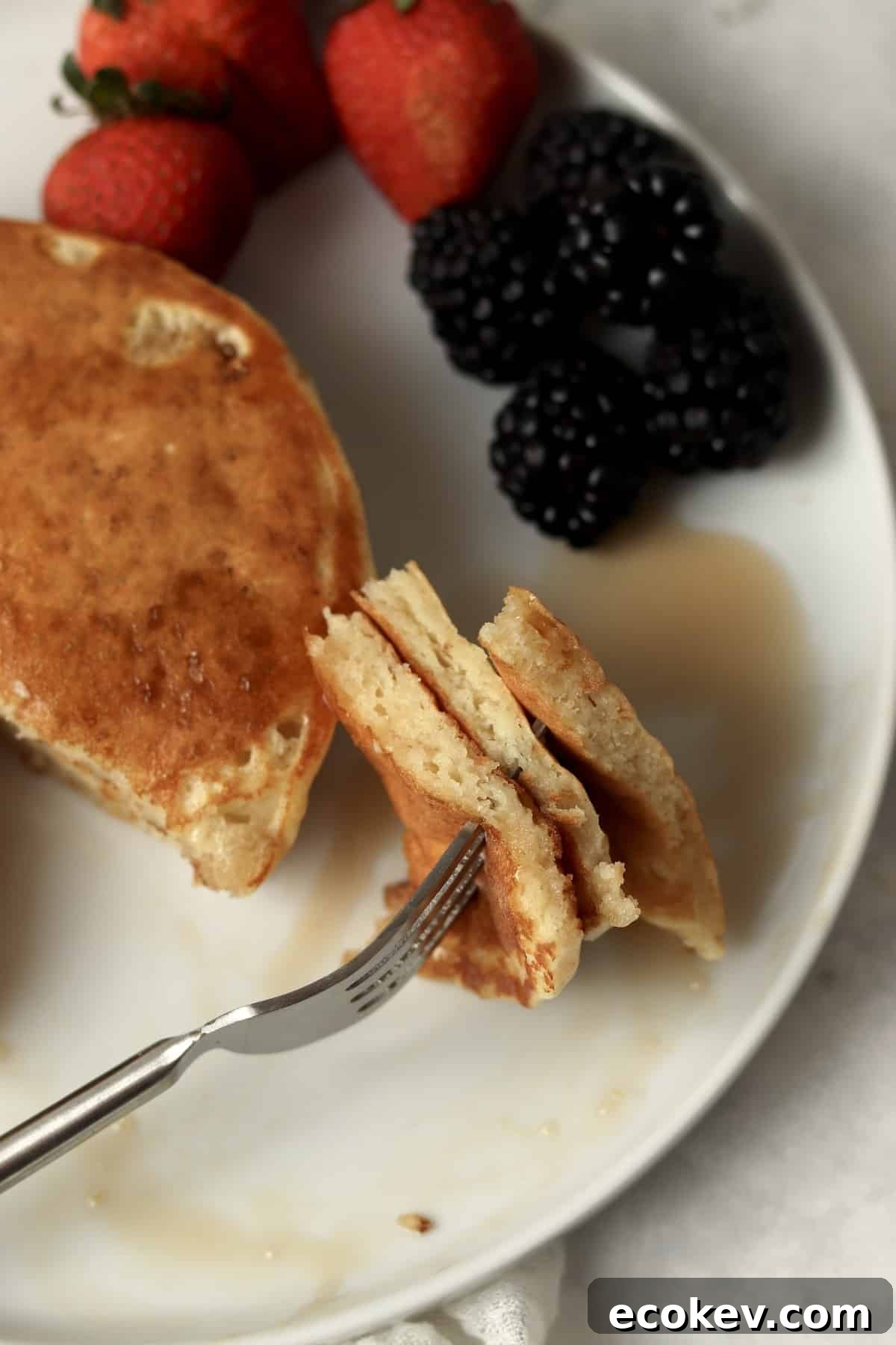 Fork with bite of pancakes to show fluffy texture.