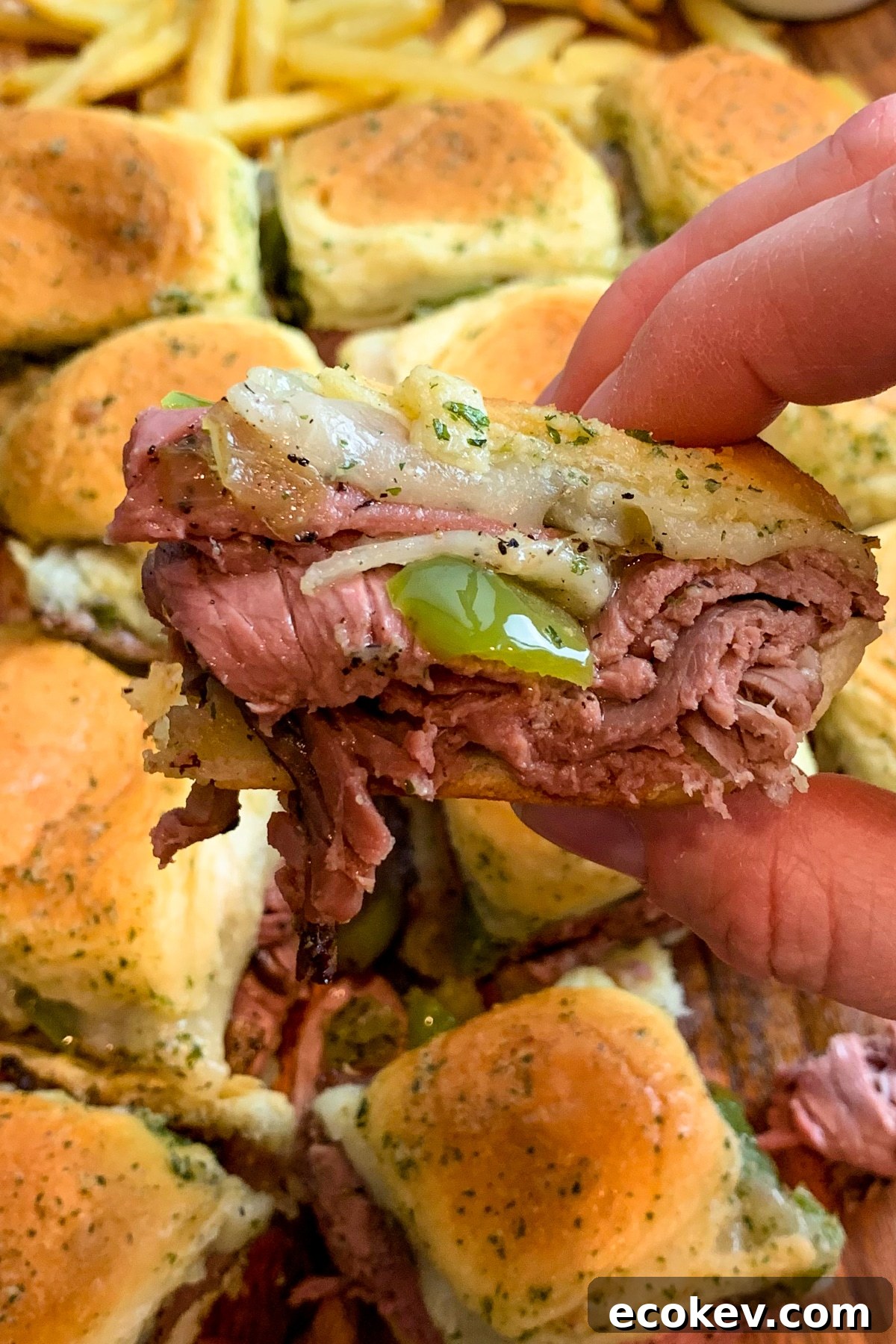 Close up of Philly cheesesteak sliders to show off the roast beef, cheese, and peppers.