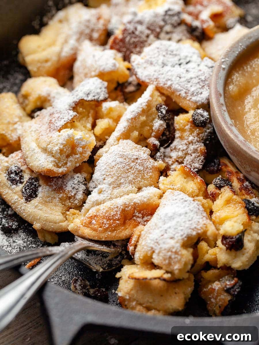 Kaiserschmarrn in a cast iron skillet dusted with powdered sugar