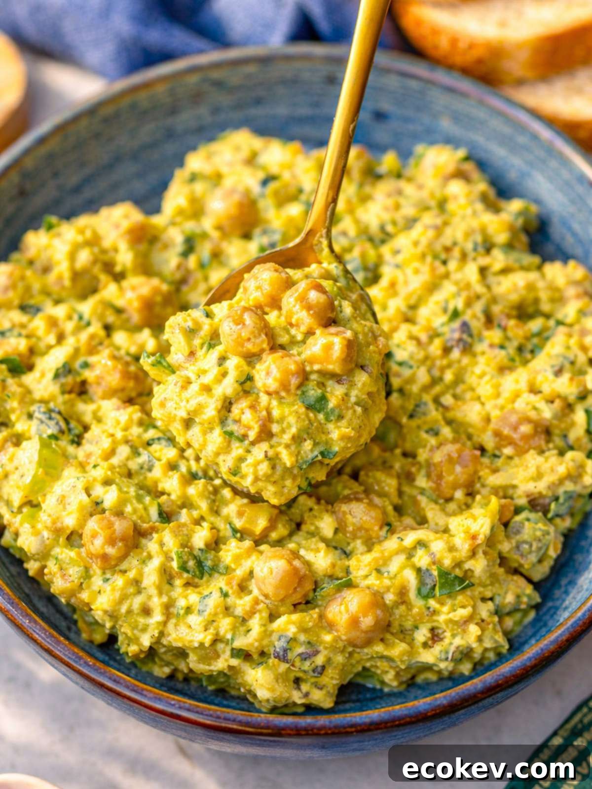 Close up of creamy chickpea salad with visible celery and herbs.