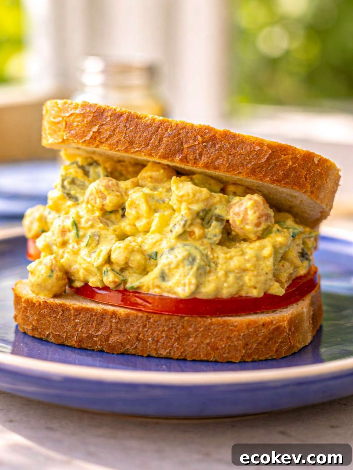 Curried chickpea salad with Greek yogurt served in a sandwich.