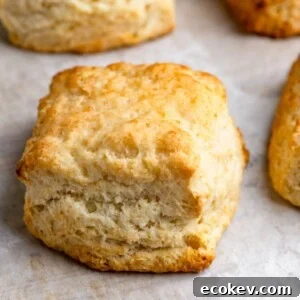 Freshly baked buttermilk biscuits on a parchment paper lined baking sheet.