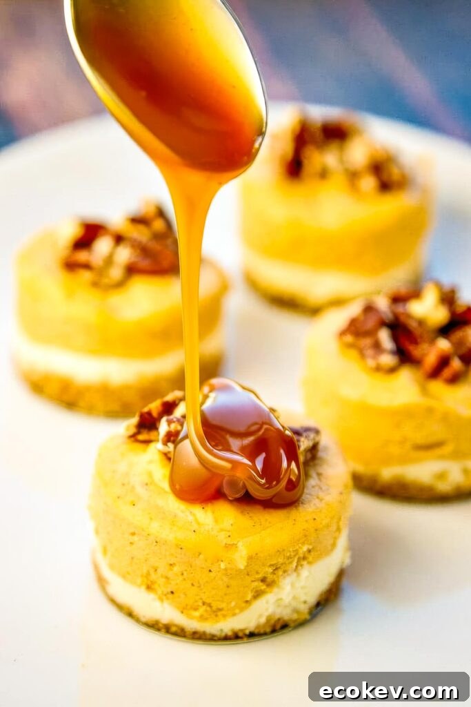 Spoon pouring caramel onto pumpkin cheesecake with pecans on a white plate