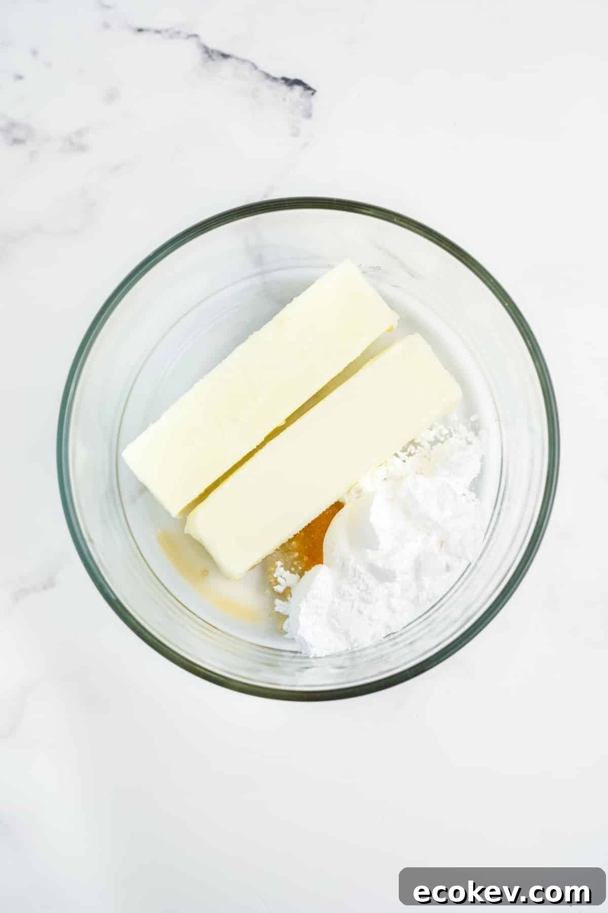 Ingredients for making strawberry butter together in a glass bowl.