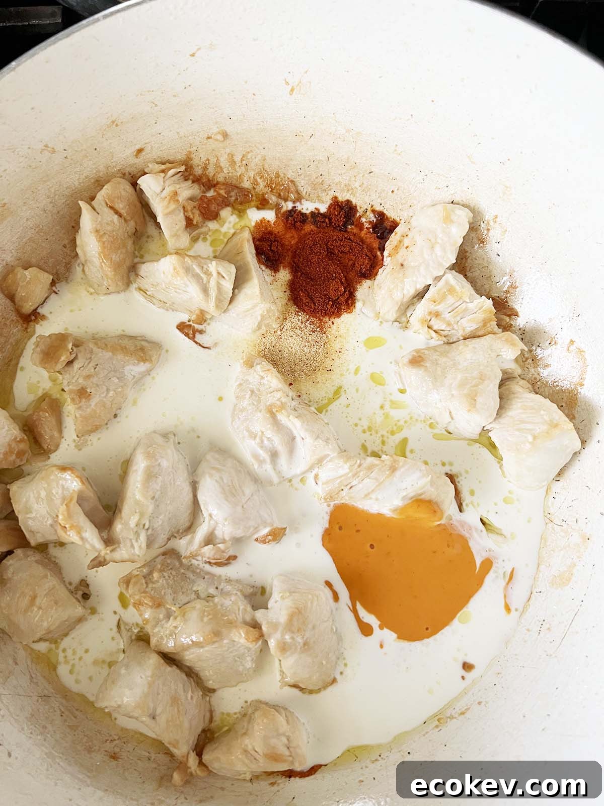 Adding spices and cream to chicken