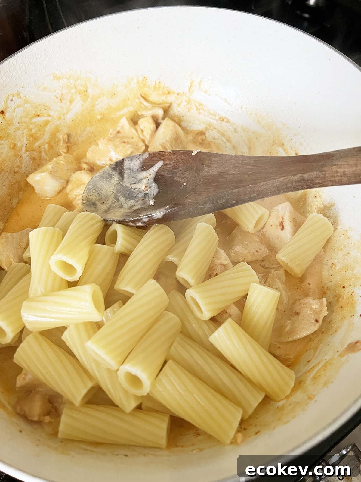 Mixing pasta into the peri peri sauce