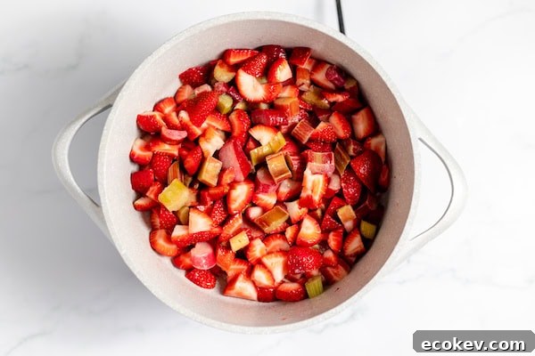 mixing strawberries and rhubarb in a pot
