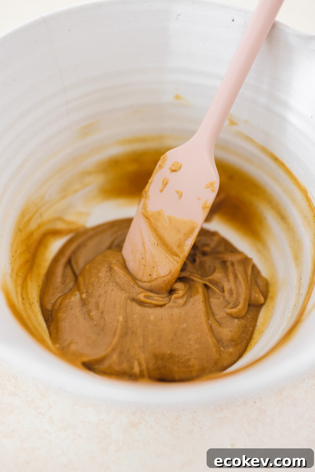 almond butter in a bowl with a pink spatula