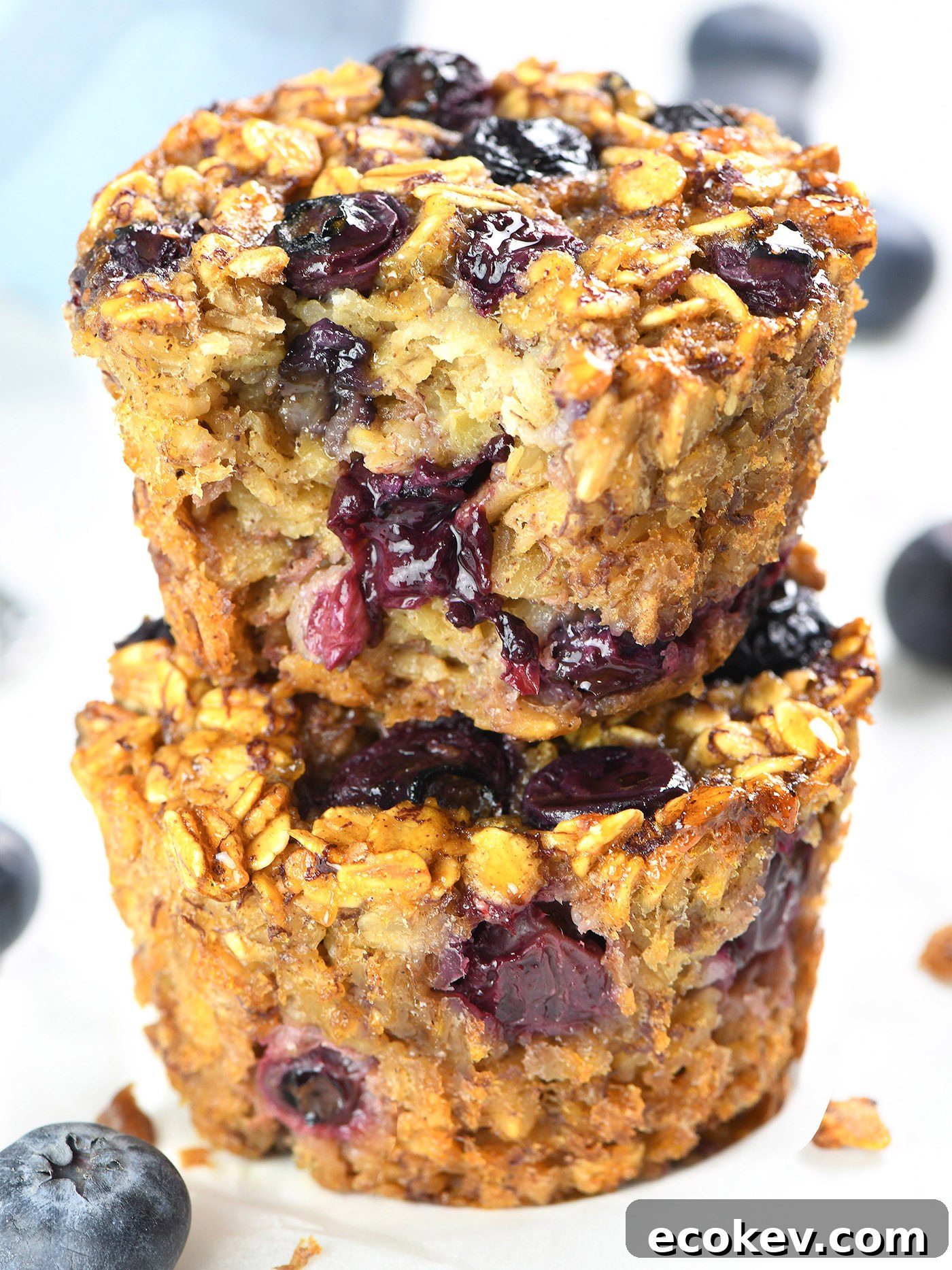 Stacked Blueberry Banana Baked Oatmeal Cups showing the moist interior filled with blueberries and oats.