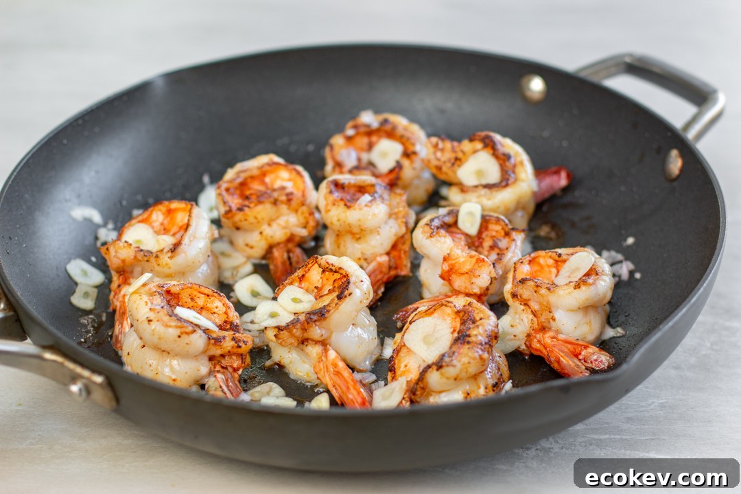 Chili-spiced shrimp are sautéed than sliced garlic is added 