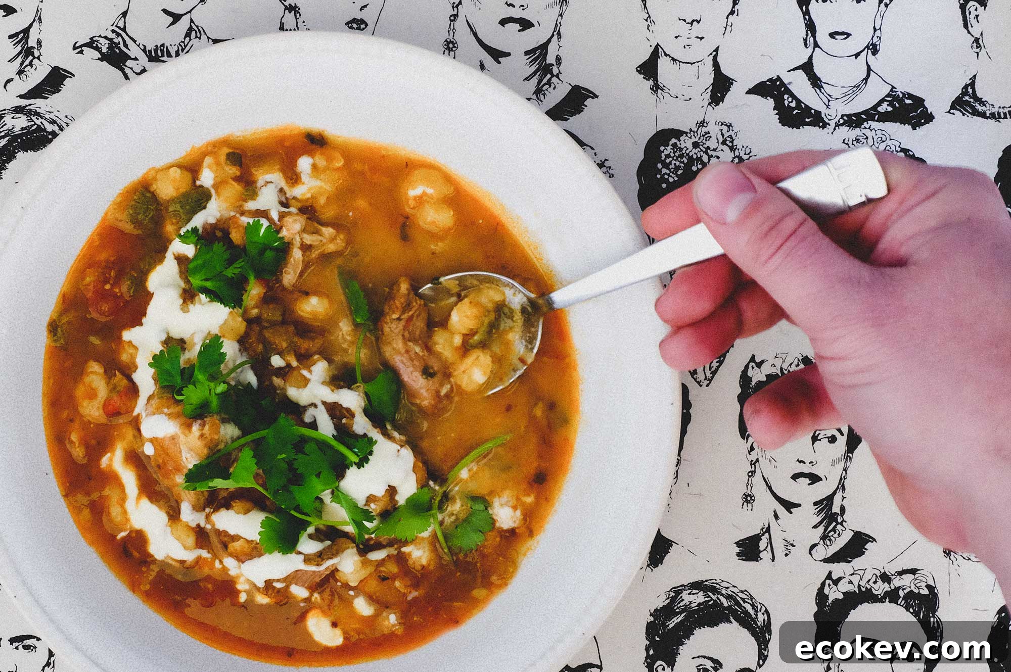 A bowl of Mexican Pozole Rojo on a background featuring sketches of Frida Kahlo