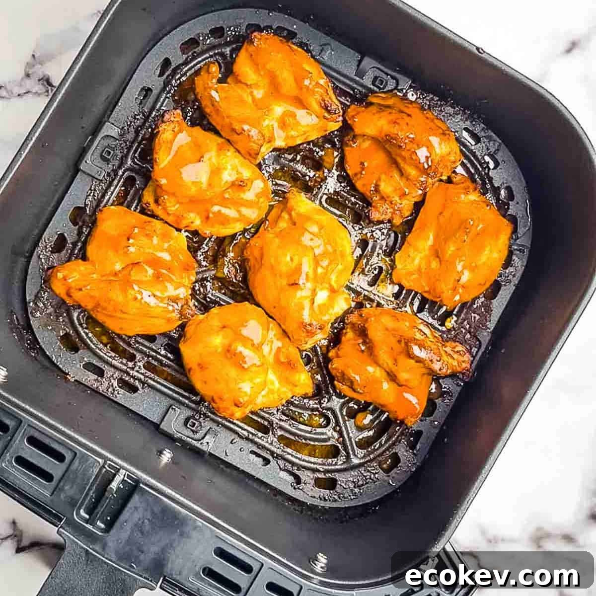 The buffalo air fryer chicken thighs when they are fully cooked in the air fryer basket.