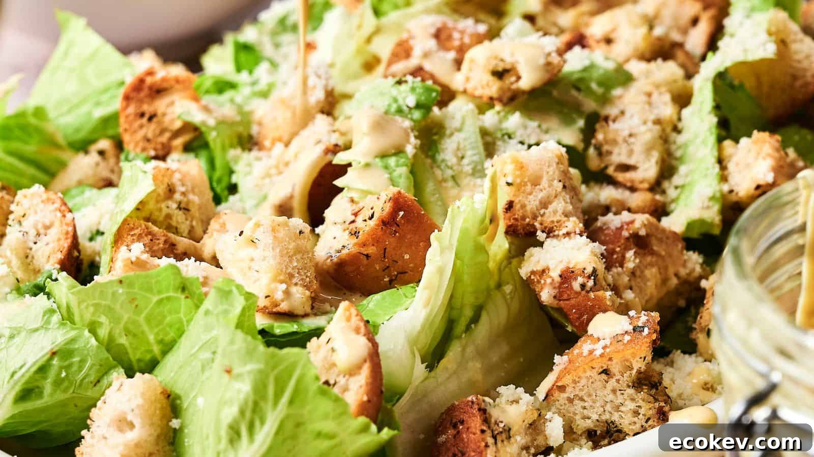 A Caesar salad with romaine lettuce, croutons, grated cheese, and dressing.