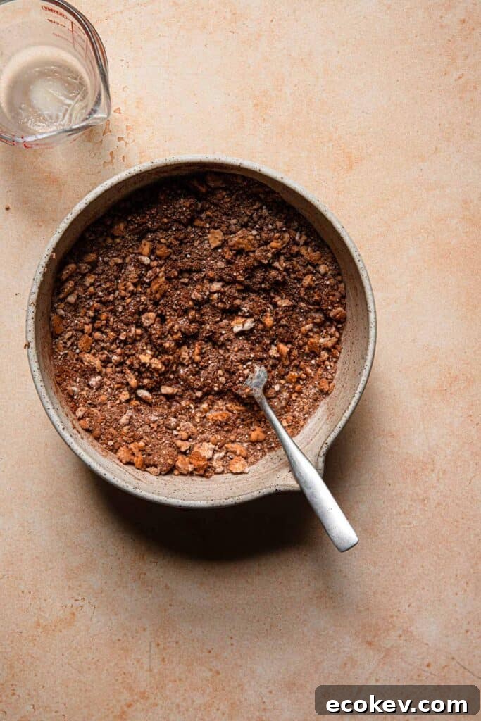 A ball with cookie mixture with a fork. A measuring cup next to it.
