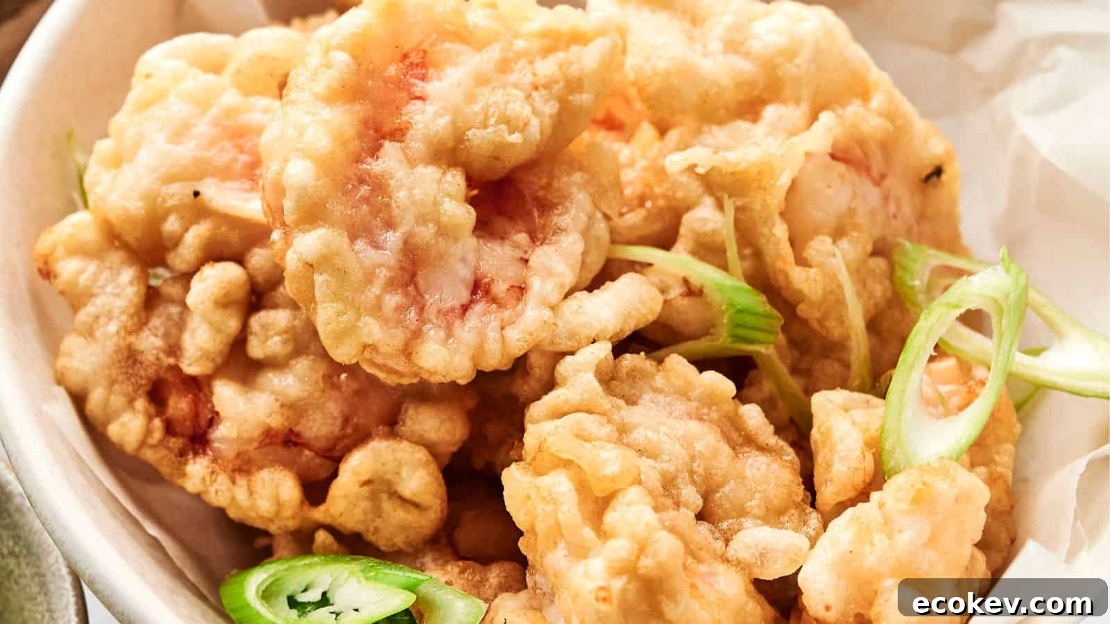 A bowl of crispy fried shrimp with slices of green onions and jalapeños.