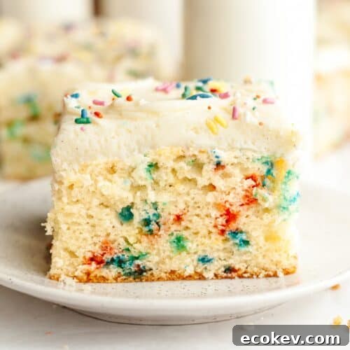 A slice of confetti sheet cake with vanilla frosting on a small plate.