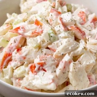 a bowl of small batch seafood salad with chopped imitation crab meat combined with onion and celery in a creamy mayonnaise dressing.