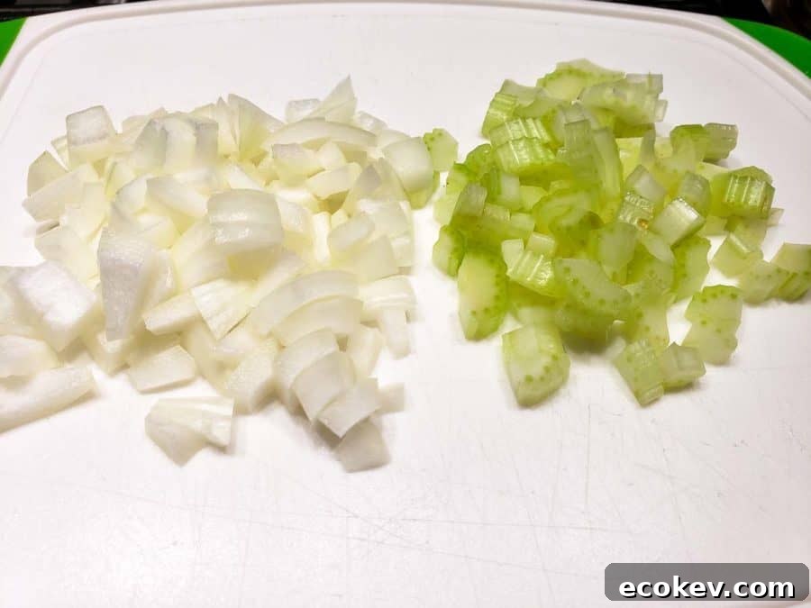 diced onions and celery on a cutting board.