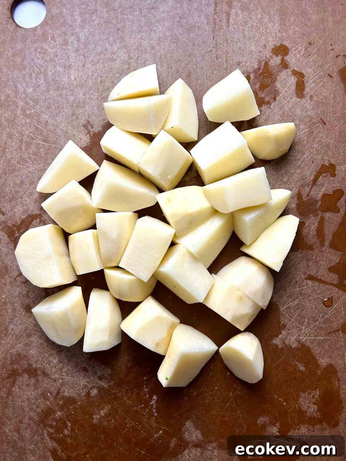 potatoes cut into chunks on cutting board.