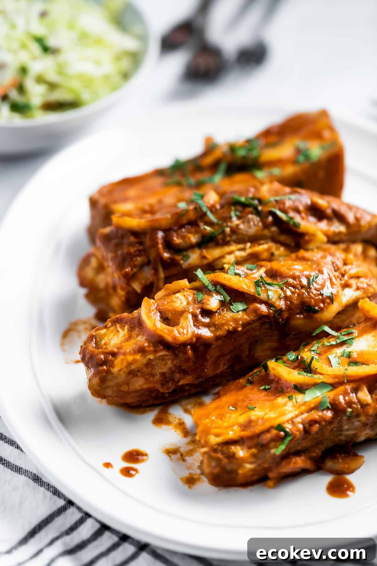 Close-up of three country style pork ribs serve on a white platter.