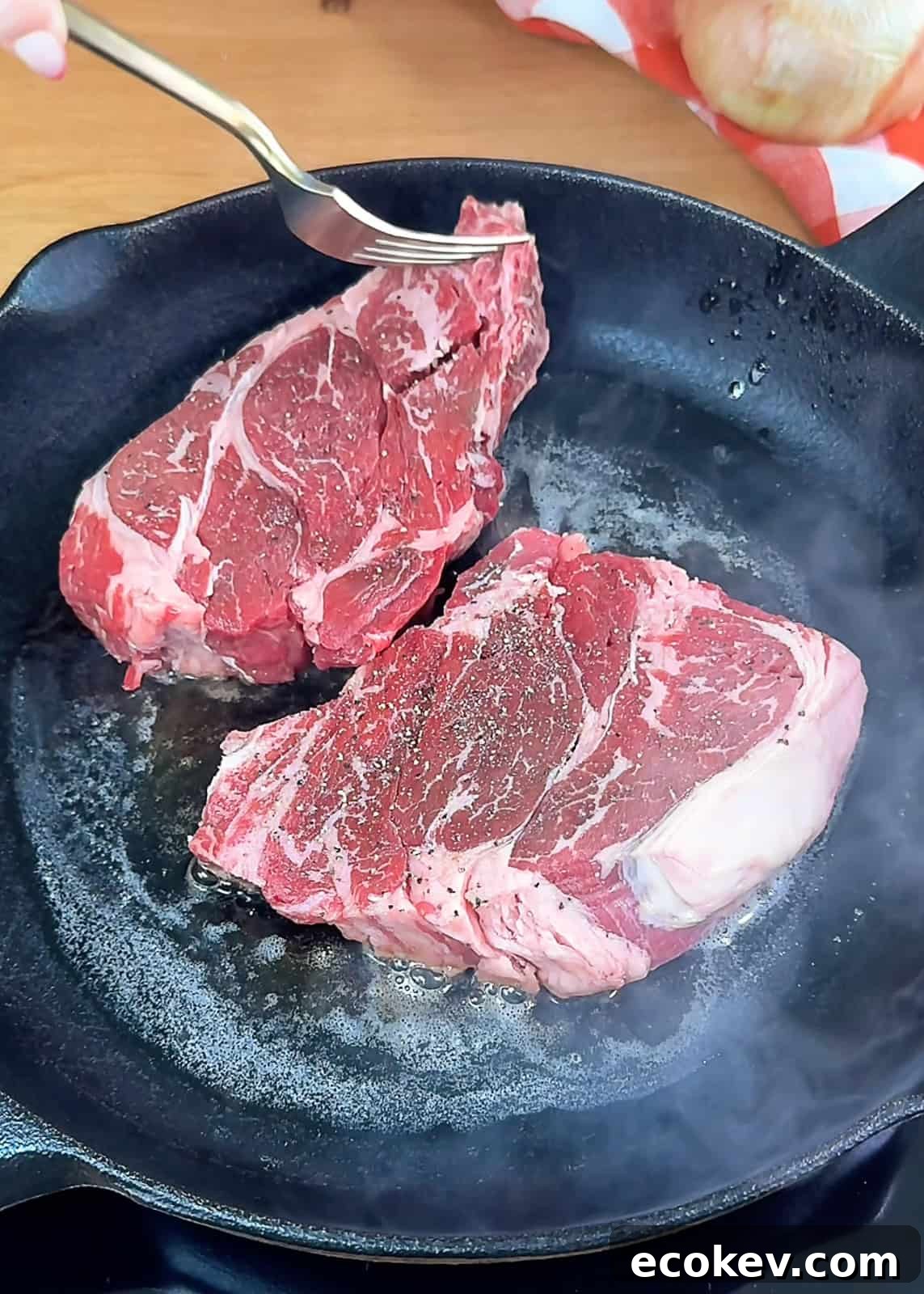 Seasoned steaks in skillet