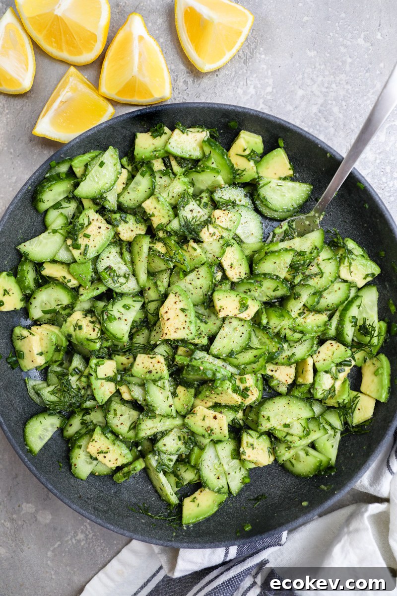 A serving bowl filled with cucumber-avocado salad used as part of a tzatziki chicken bowl