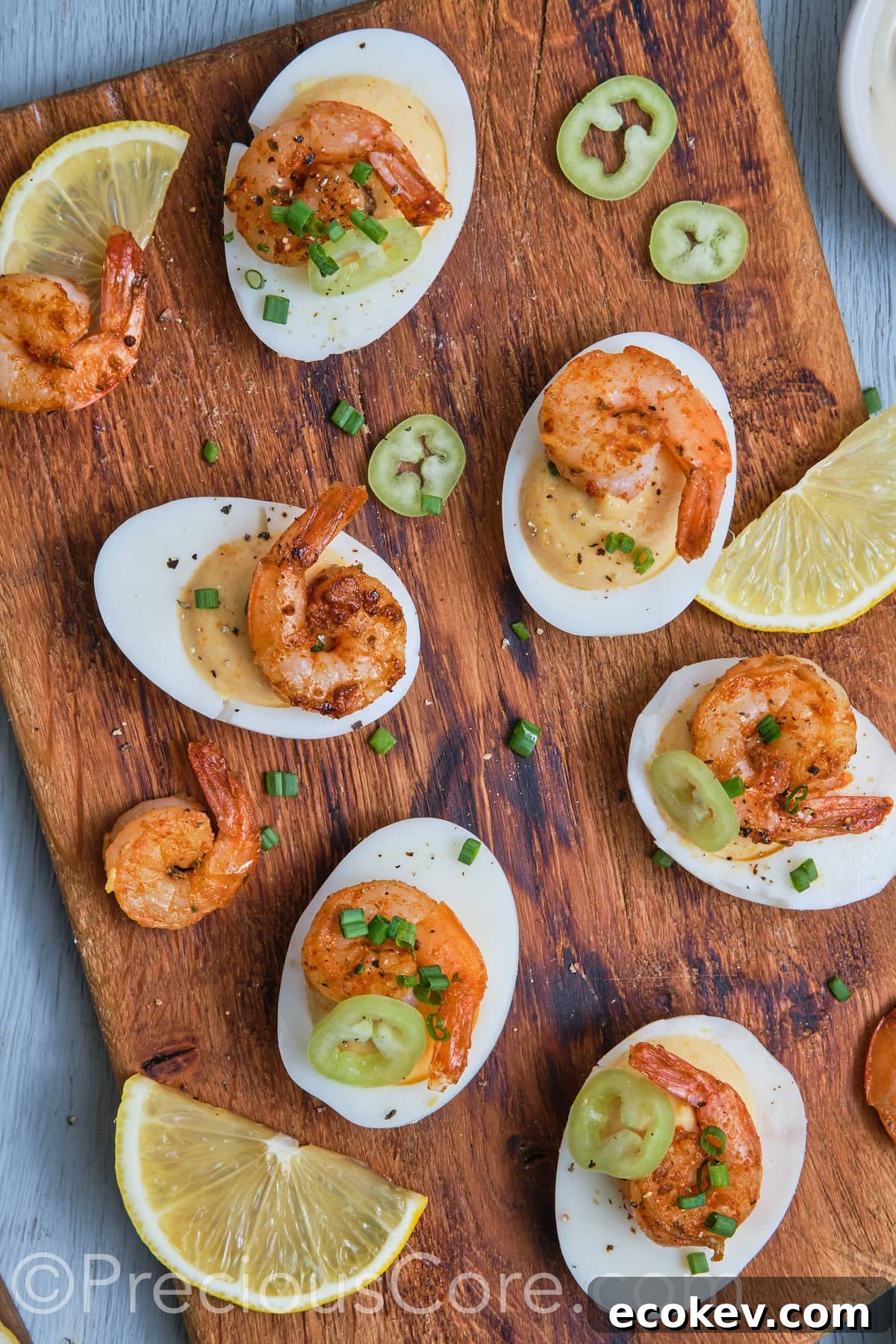 Deviled eggs with shrimp on a chopping board. 